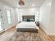 Bright bedroom with a tufted headboard, neutral color palette, and stylish chandelier at 3180 Lee Dr, Buford, GA 30518