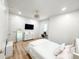 Bright bedroom featuring wood floors, a white-framed bed, a mirrored dresser, a ceiling fan, and a tv at 3180 Lee Dr, Buford, GA 30518