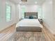 Spacious bedroom featuring a tufted headboard, wood floors, and abundant natural light at 3180 Lee Dr, Buford, GA 30518