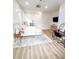 Bright bedroom featuring wood floors, a white and gray patterned rug, a television, and a desk with a mirror at 3180 Lee Dr, Buford, GA 30518
