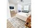 Bright bedroom featuring wood floors, a gray sofa, a gray and white patterned rug and a television at 3180 Lee Dr, Buford, GA 30518