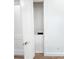 Small linen closet with shelves near an open door and oak flooring at 3180 Lee Dr, Buford, GA 30518