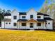 Stunning two-story modern farmhouse with white siding and a welcoming front porch at 3180 Lee Dr, Buford, GA 30518