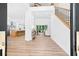 Bright and airy foyer boasts wood floors, open floor plan and a stairway with black iron balusters at 3180 Lee Dr, Buford, GA 30518