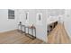 Bright hallway with light wood floors and minimalist tables below the windows at 3180 Lee Dr, Buford, GA 30518