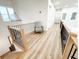 Hallway overlooking staircase features wood flooring and a modern metal railing at 3180 Lee Dr, Buford, GA 30518