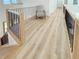 Hallway overlooking the living room featuring hardwood floors and metal railings at 3180 Lee Dr, Buford, GA 30518
