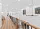 A long hallway with wood floors, a modern railing, and recessed lighting at 3180 Lee Dr, Buford, GA 30518