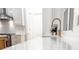 Kitchen featuring white cabinets, marble countertops, and a stylish gold faucet at 3180 Lee Dr, Buford, GA 30518