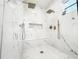 This walk-in shower features marble-style tile, dual rainfall shower heads, and seamless glass doors at 3180 Lee Dr, Buford, GA 30518