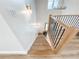 Bright staircase with wood and black metal railings, illuminated by modern light fixtures on white walls at 3180 Lee Dr, Buford, GA 30518
