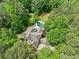 Aerial view of a house surrounded by lush trees, showcasing the private backyard with a sparkling pool at 8170 Hurakan Creek Xing, Cumming, GA 30028