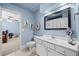 Charming blue bathroom featuring a white vanity, a toilet, and coastal decor at 8170 Hurakan Creek Xing, Cumming, GA 30028