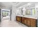 A luxurious bathroom with double vanities, decorative mirrors, and access to the primary bedroom at 8170 Hurakan Creek Xing, Cumming, GA 30028