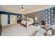 A spacious primary bedroom featuring unique wallpaper, neutral carpet, a sitting area, and bathroom access at 8170 Hurakan Creek Xing, Cumming, GA 30028