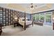 Spacious bedroom featuring a tray ceiling, decorative wallpaper, and a sitting area with outdoor views at 8170 Hurakan Creek Xing, Cumming, GA 30028