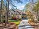 Traditional two-story home showcasing a manicured front lawn, a porte-cochere, and mature trees at 8170 Hurakan Creek Xing, Cumming, GA 30028