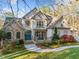 Charming two-story home featuring a stone facade, a welcoming front porch, and manicured landscaping at 8170 Hurakan Creek Xing, Cumming, GA 30028