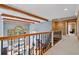 A second-floor hallway with exposed beams overlooking the great room and the backyard pool at 8170 Hurakan Creek Xing, Cumming, GA 30028