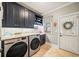 Modern laundry room featuring front load washer and dryer with custom counterspace and storage at 8170 Hurakan Creek Xing, Cumming, GA 30028