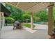 An outdoor patio area with a table and chairs, a view of the pool, and a surrounding wooded area at 8170 Hurakan Creek Xing, Cumming, GA 30028
