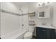 This bathroom has a shower and tub combo, white tile, gray accents and a dark blue vanity at 111 Northdale Pl, Lawrenceville, GA 30046