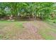 Green grassy backyard with a nice wooded surround and a small firepit area at 162 Riverchase Dr, Woodstock, GA 30188