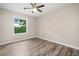 This bedroom has a ceiling fan, light colored walls, and wood-look vinyl flooring at 162 Riverchase Dr, Woodstock, GA 30188