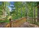 Wooden deck with forest views, surrounded by lush trees and green foliage at 162 Riverchase Dr, Woodstock, GA 30188