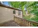 Side view of home and wooden deck, surrounded by mature trees at 162 Riverchase Dr, Woodstock, GA 30188