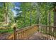 A wood deck overlooks a beautiful lush green lot surrounded by trees at 162 Riverchase Dr, Woodstock, GA 30188