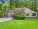 Charming home featuring a two-car garage, well-maintained lawn, and beautiful landscaping and mature trees at 162 Riverchase Dr, Woodstock, GA 30188