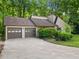Charming home featuring a two-car garage and driveway surrounded by mature trees and landscaping at 162 Riverchase Dr, Woodstock, GA 30188