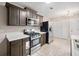 A kitchen featuring dark cabinets, stainless appliances, white counter tops and tile floors at 162 Riverchase Dr, Woodstock, GA 30188