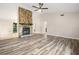 Open living room with wood-look flooring, a stone fireplace, and a seamless transition to other spaces at 162 Riverchase Dr, Woodstock, GA 30188