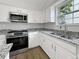 Close-up of the updated kitchen featuring a stainless-steel range and granite counters at 2628 Downingwood Ln, Grayson, GA 30017