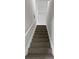 Carpeted staircase with white railings provides a safe transition between floors at 2628 Downingwood Ln, Grayson, GA 30017