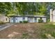 A single-story home with light siding, a stone accent, and a long driveway at 5445 Mallard Trl, Lithonia, GA 30058
