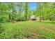 Expansive backyard with lush greenery surrounding a two-story home featuring a deck at 5911 Christopher Ln, Lithonia, GA 30058