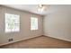 Bright bedroom features neutral walls, carpeted floors, a ceiling fan, and natural light from two windows at 5911 Christopher Ln, Lithonia, GA 30058
