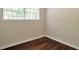 Cozy bedroom features stylish wood-look flooring, neutral walls, and a window with blinds for privacy at 5911 Christopher Ln, Lithonia, GA 30058