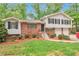 Charming brick home featuring black shutters, a well-manicured lawn, and a two-car garage at 5911 Christopher Ln, Lithonia, GA 30058
