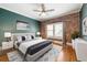 This bedroom features a brick wall, hardwood floors, and an overhead fan and stylish decor at 960 Taft Ne Ave # 9, Atlanta, GA 30309