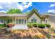 Back exterior featuring a stone patio, manicured lawn, lush green shrubs, and sliding glass doors at 3219 Abbott Dr # 5, Powder Springs, GA 30127