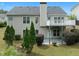 Two-story home with a balcony, a patio, and a lush green backyard with mature trees at 4219 David Austin Ct, Snellville, GA 30039