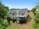 Two-story home with a balcony, a patio, and a lush green backyard with mature trees at 4219 David Austin Ct, Snellville, GA 30039