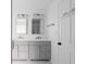 Bright bathroom featuring double vanity with gray cabinets, mirrors, and modern lighting at 4219 David Austin Ct, Snellville, GA 30039