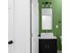 Modern bathroom with green accent wall, marble countertop, and sleek black vanity at 4219 David Austin Ct, Snellville, GA 30039