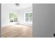 Bedroom with light wood flooring, a modern light fixture, and ample natural light from the large window at 4219 David Austin Ct, Snellville, GA 30039