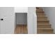 Staircase with hardwood steps, a door, and a storage area under the staircase at 4219 David Austin Ct, Snellville, GA 30039